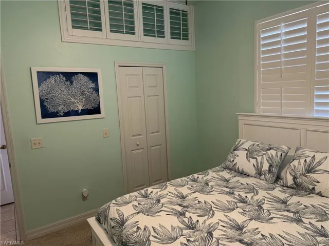 Carpeted bedroom with a closet and baseboards
