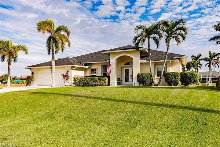 View of front facade featuring a front yard, concrete driveway, a garage, and stucco siding