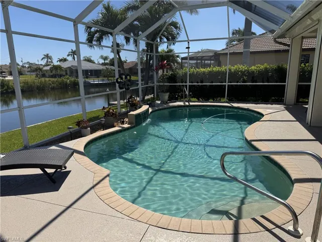 View of pool featuring a water view, a patio area, glass enclosure, and a fenced in pool