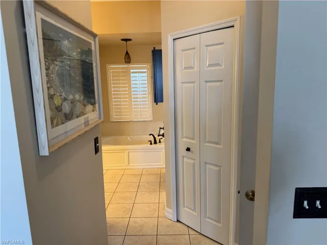 Corridor with light tile patterned flooring