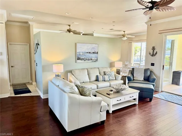 Living area with crown molding, hardwood / wood-style floors, and a ceiling fan