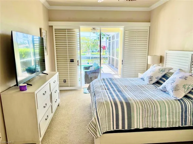 Bedroom featuring ornamental molding, light colored carpet, and access to exterior
