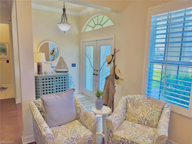 Living area featuring baseboards, french doors, wood finished floors, and ornamental molding