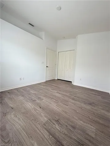 Unfurnished bedroom with dark wood-type flooring and a closet