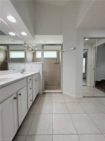 Full bathroom featuring double vanity, recessed lighting, a stall shower, and tile patterned flooring