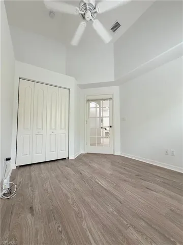 Unfurnished bedroom featuring wood finished floors, a closet, and ceiling fan