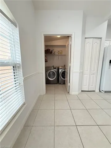 Laundry room featuring washer and clothes dryer and light tile patterned floors