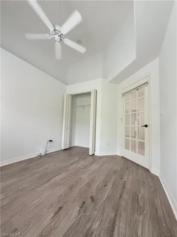 Unfurnished bedroom with wood finished floors, a closet, and ceiling fan