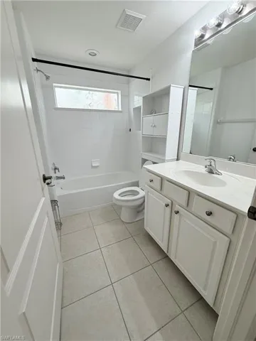 Bathroom with tile patterned floors, vanity, and shower / bathtub combination
