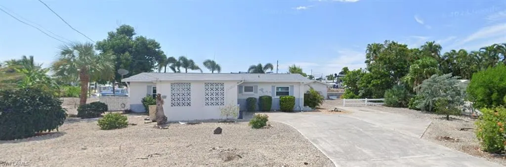 View of front facade with concrete driveway and stucco siding