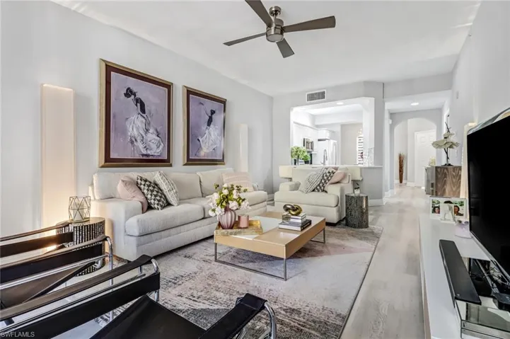 Living room with light hardwood / wood-style floors and ceiling fan