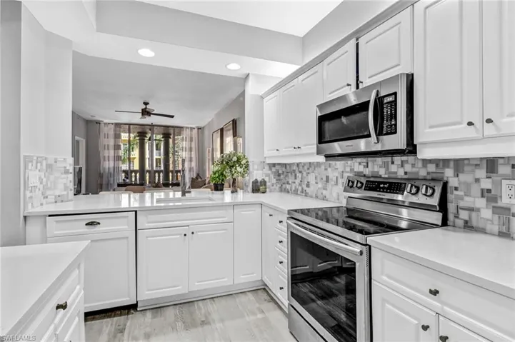 Kitchen featuring tasteful backsplash, sink, white cabinetry, appliances with stainless steel finishes, and ceiling fan