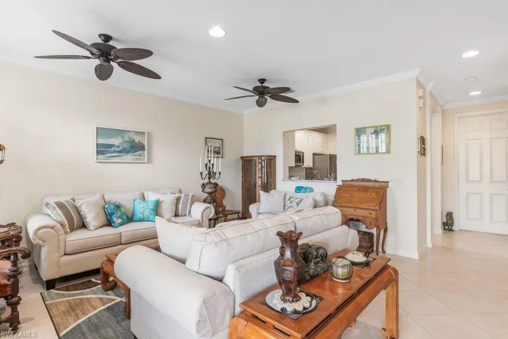 Tiled living room featuring crown molding, recessed lighting, and a ceiling fan