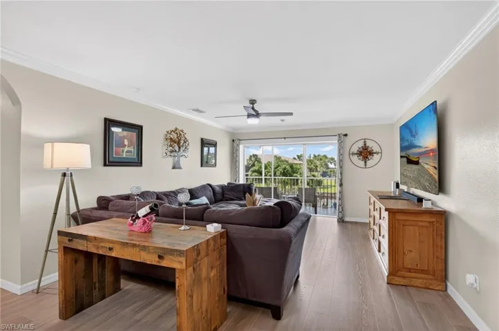Spacious living area featuring wood-finish flooring and crown molding