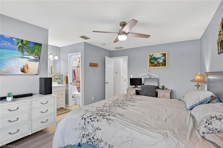 Bedroom featuring light gray walls, wood-finish flooring, and a ceiling fan with integrated lighting