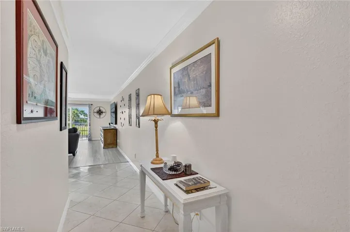 Hallway featuring crown molding and neutral wall tones