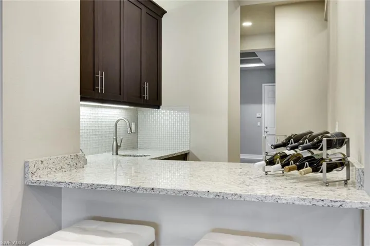 Built in Wet Bar with Solid Wood Cabinetry and Glass Back Splash