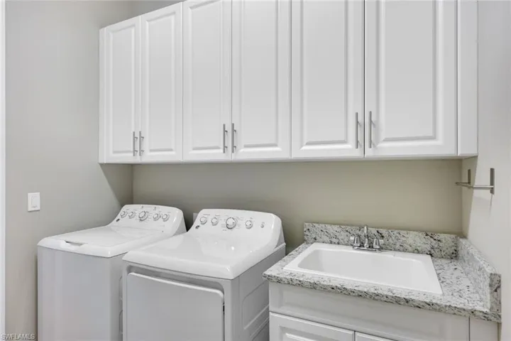 Appointed Laundry Room with Cabinets and Granite Counters