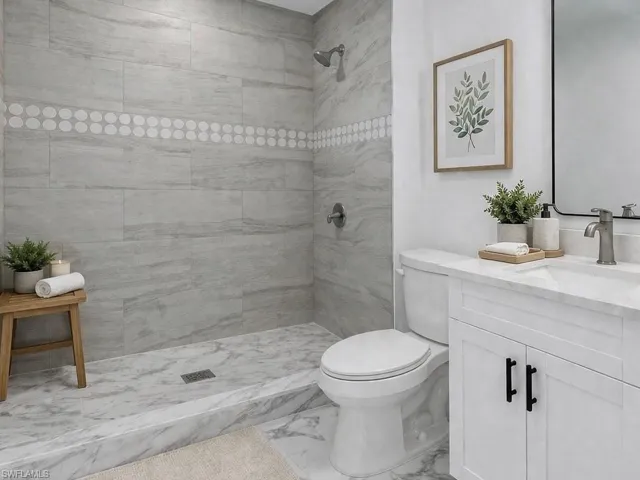 Bathroom featuring vanity and tiled shower