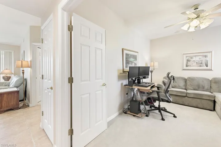 Home office with ceiling fan and carpet