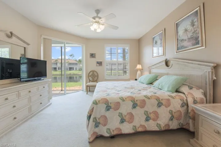 Bedroom with ceiling fan, access to exterior, and light colored carpet