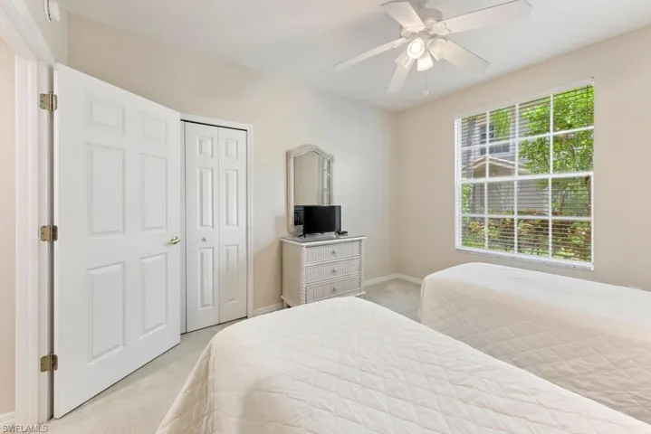 Bedroom featuring light colored carpet, a closet, and ceiling fan