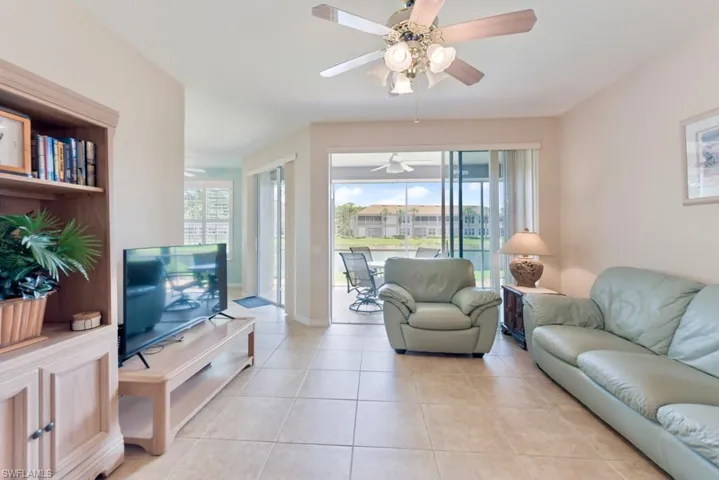 Tiled living room featuring a wealth of natural light and ceiling fan