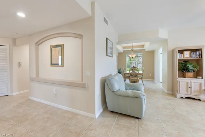 Living room with light tile floors and a raised ceiling