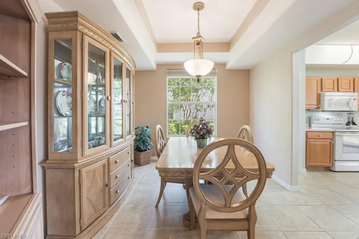 Tiled dining room with a tray ceiling