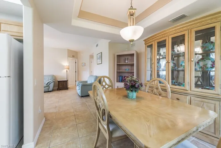 Dining space with light tile floors and a raised ceiling