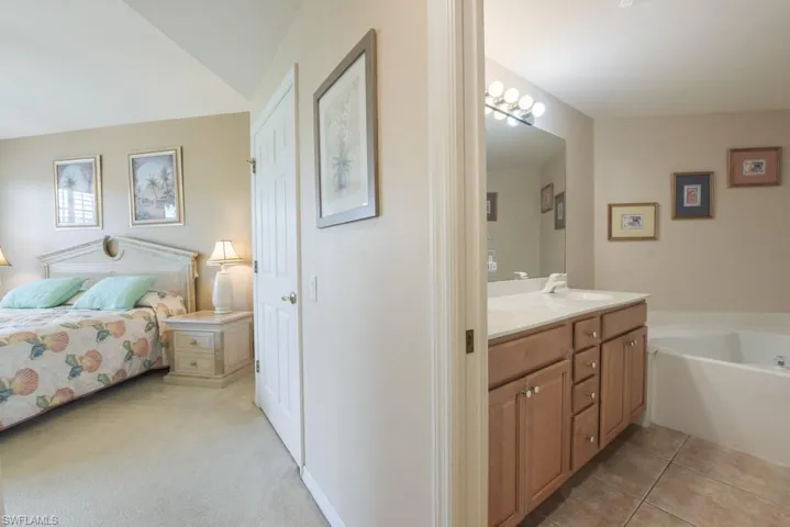 Bathroom with tile flooring, dual vanity, and a bath
