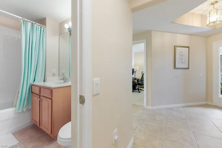 Full bathroom featuring toilet, vanity, shower / bath combo, and tile floors