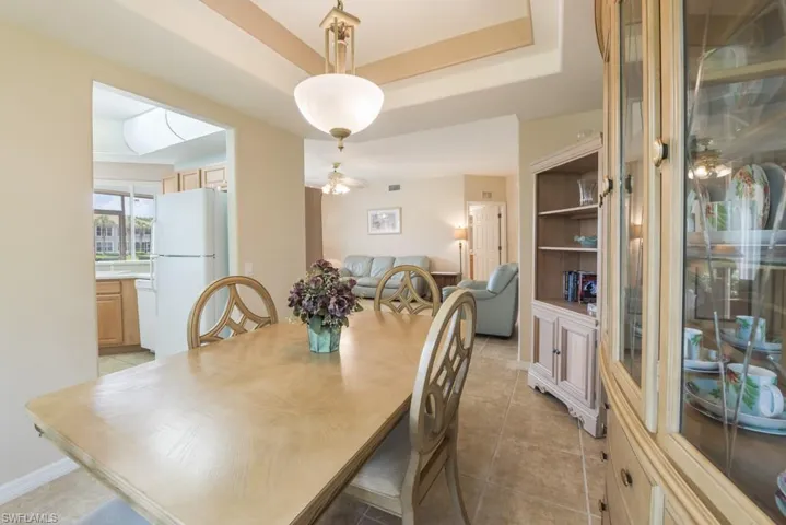 Tiled dining space with a tray ceiling