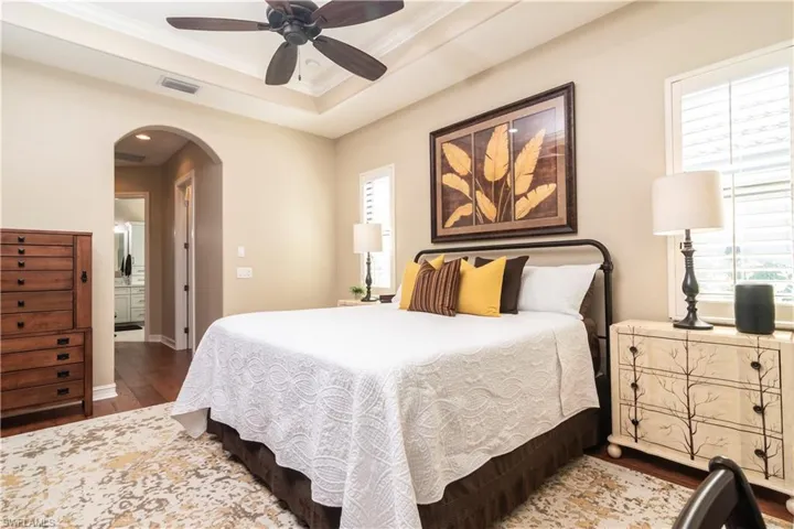 Master Bedroom with multiple windows, ceiling fan, and dark hardwood / wood floors
