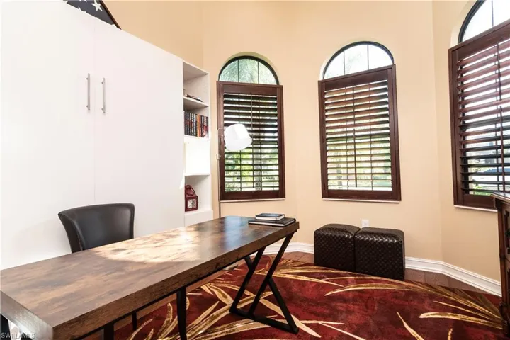 Home office featuring wood flooring, plantation shutters