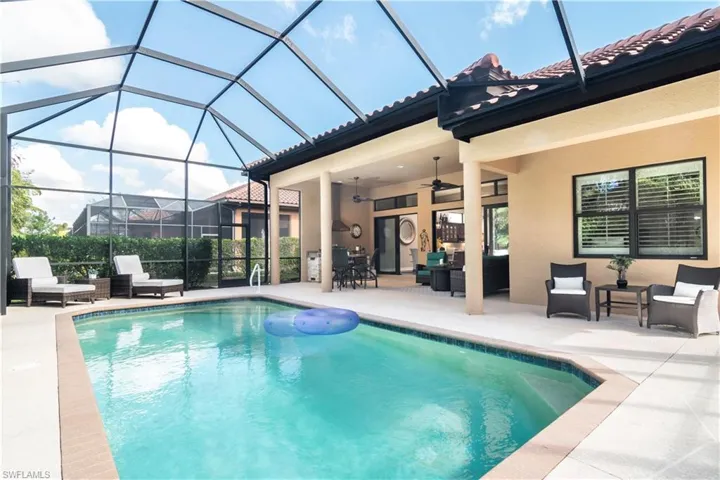 View of swimming pool featuring a lanai, ceiling fan, an outdoor living space, and a patio area