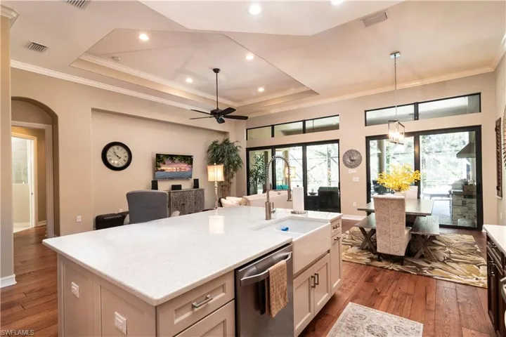 Kitchen with a center island with sink, white cabinetry, sink, hardwood / wood-style floors, and dishwasher