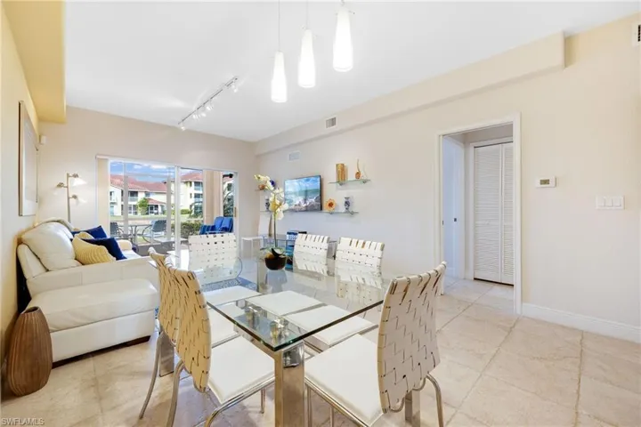 Dining space featuring rail lighting and light tile patterned floors