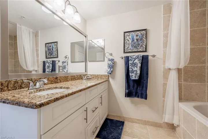 Bathroom featuring shower / bath combo, tile patterned floors, and vanity