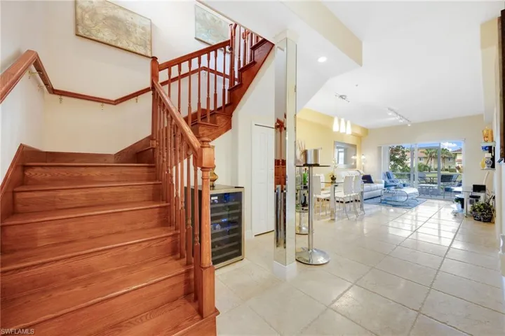 Stairs featuring rail lighting and wine cooler