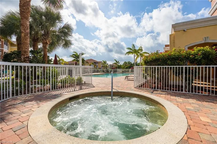 View of pool with a patio area and a hot tub