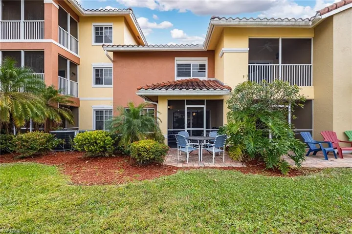Rear view of property, a patio, and a lawn