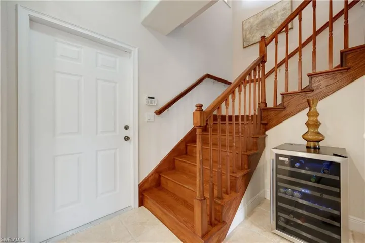 Stairway with wine cooler and tile patterned floors