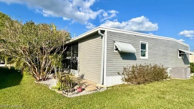 View of side of property with a lawn