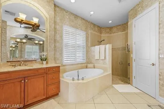 Bathroom featuring vanity, independent shower and bath, tile patterned floors, and ceiling fan