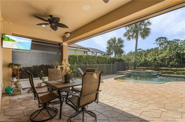 View of patio / terrace featuring ceiling fan and a swimming pool with hot tub