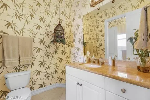 Bathroom with vanity, toilet, and tile patterned flooring