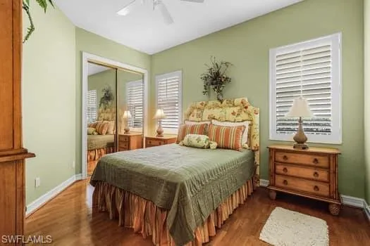 Bedroom featuring dark hardwood / wood-style floors, a closet, and ceiling fan