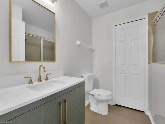 Bathroom with hardwood / wood-style flooring, toilet, and oversized vanity