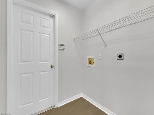 Laundry area with dark wood-type flooring, hookup for an electric dryer, and hookup for a washing machine